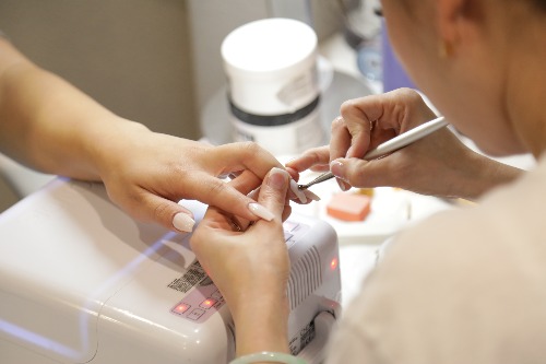 A beauty technician providing nail care services.